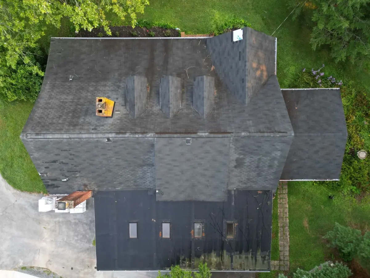 A close-up of a residential asphalt roof in East Tennessee showing wear on the south-facing slope.