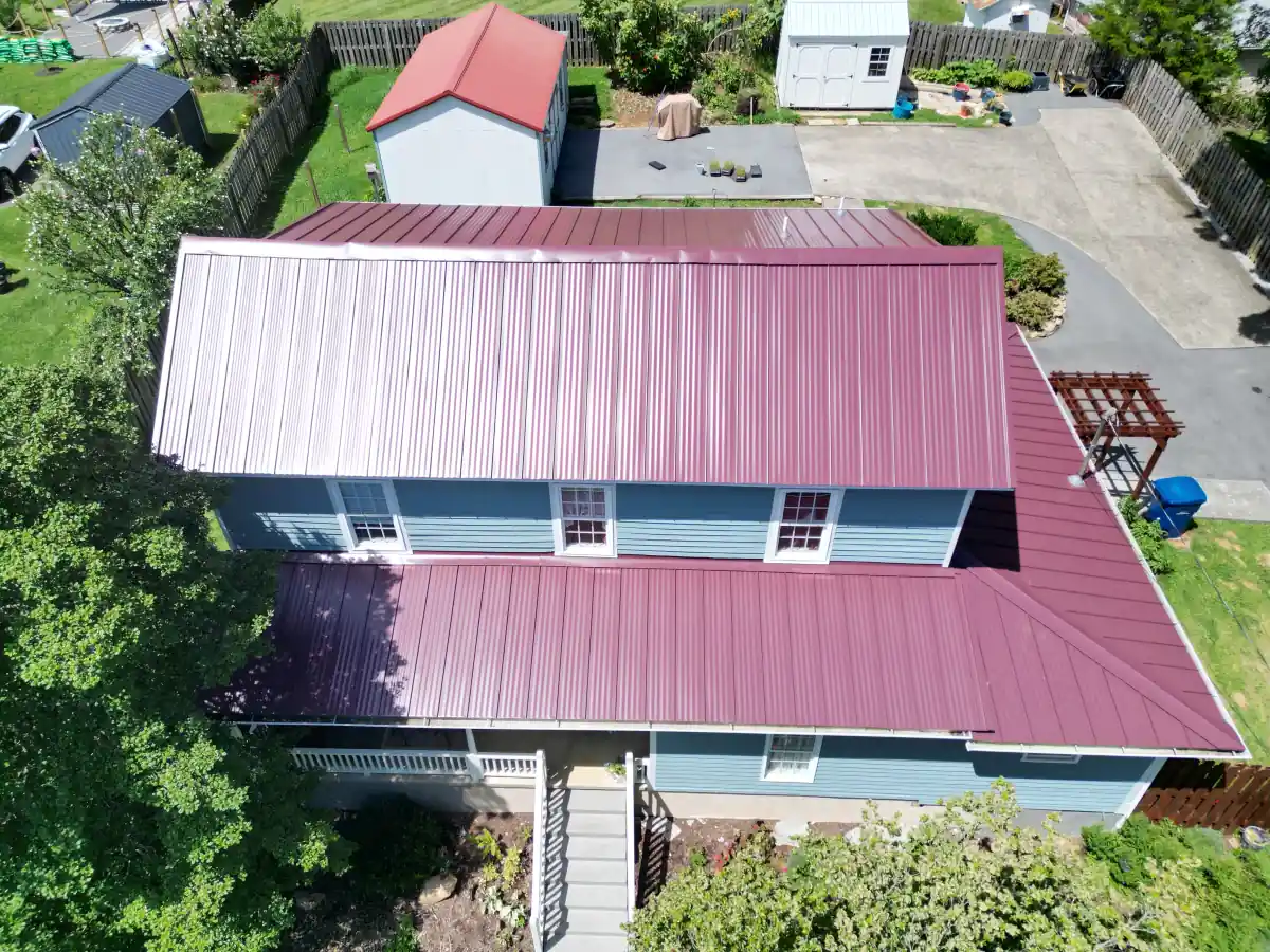Red metal roof on a blue two-story home — completed by Palisade Roofing in East Tennessee.